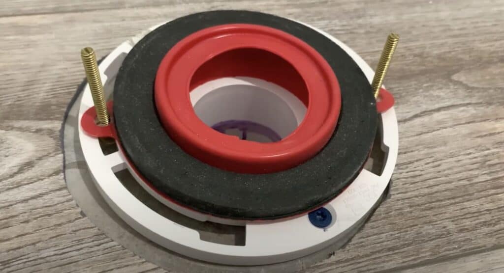 Install a wax ring (or a wax free seal in this case) over the basement toilet flange